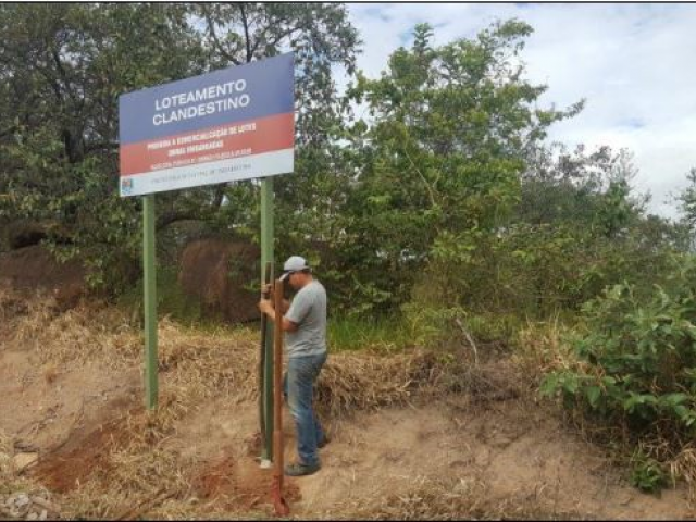 Placa colocada pela administração municipal informando da irregularidade da instalação dos moradores