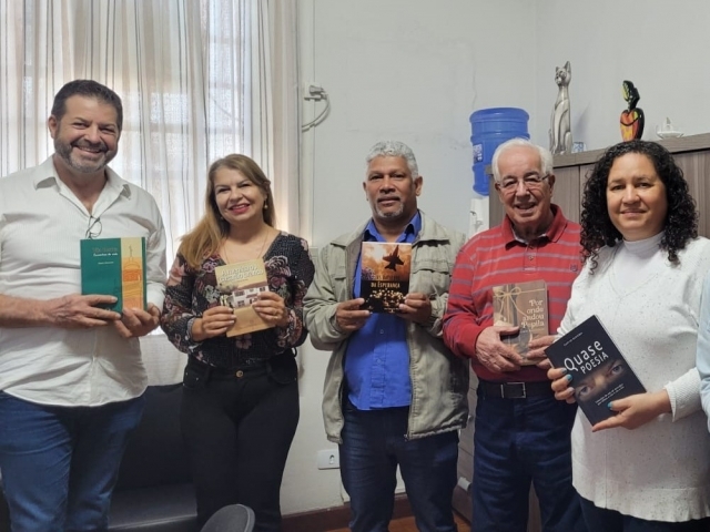 Os escritores Eloy Oliveira, Alberto Manavello e Mércia Falcini com a diretora Cidinha e os professores José Antônio dos Santos e Eliana Camargo dos Reis seguram os livros doados